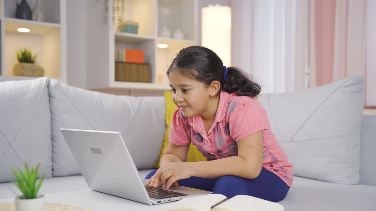 satisfecha con lo que ve en el portátil, la niña asiente con la cabeza.