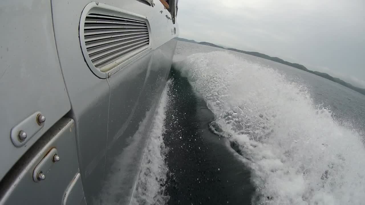 side of boat wash splashing up partly slow motion