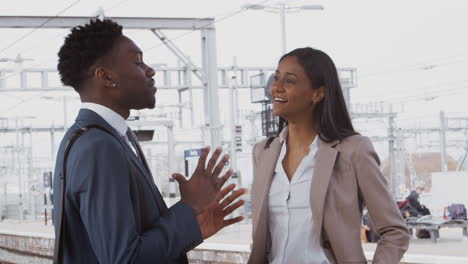 hombre de negocios y mujer de negocios que viajan al trabajo hablando en la plataforma ferroviaria esperando el tren