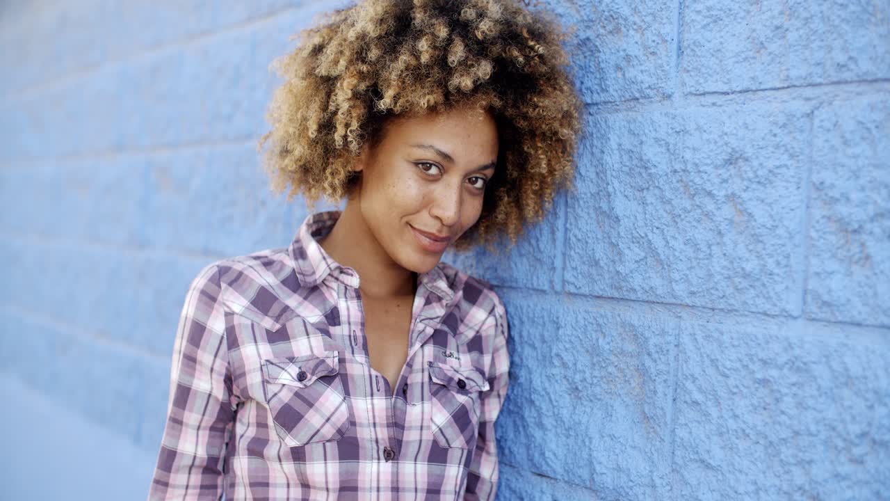Black Woman Leaning Against Wall