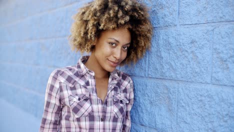 mujer negra apoyada contra la pared