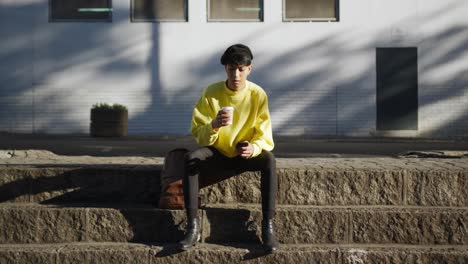 transgender adult drinking coffee in the street