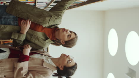 mujeres jóvenes discutiendo libros en la biblioteca