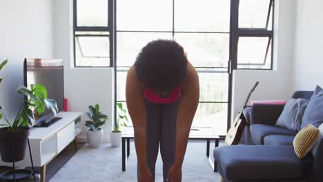 mujer afroamericana de tamaño grande de pie en un tapete de ejercicio trabajando