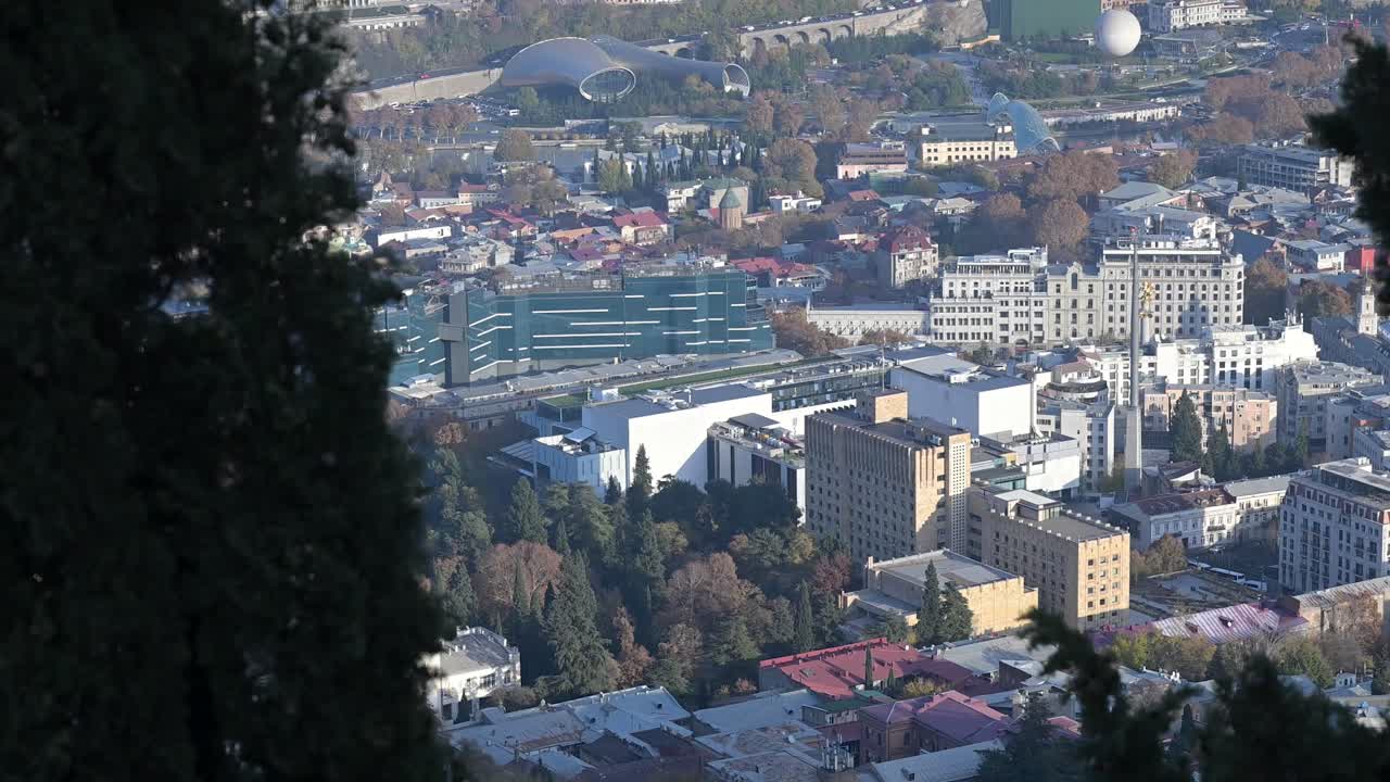 Looking out from the hillside over Tbilisi with a clear view across the town and surrounding landscape capturing the peaceful atmosphere