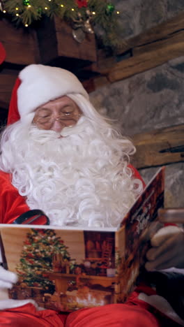santa claus reading book. santa claus in beautiful room next to the fireplace vertical video