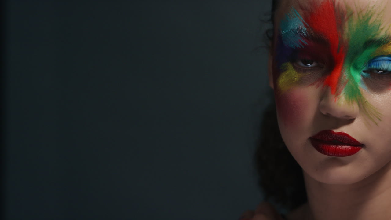 retrato de cerca de una mujer hermosa con una pintura de rostro colorida arte corporal multicolor exótico mujer sensual que disfruta de la expresión creativa