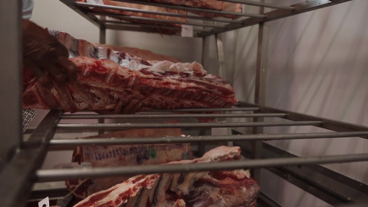 Fresh rib sections are stacked onto a stainless steel rack to dry age at industrial butchery.
