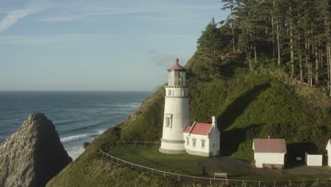 aerial flying close to haceta head lighthouse with coastline in background