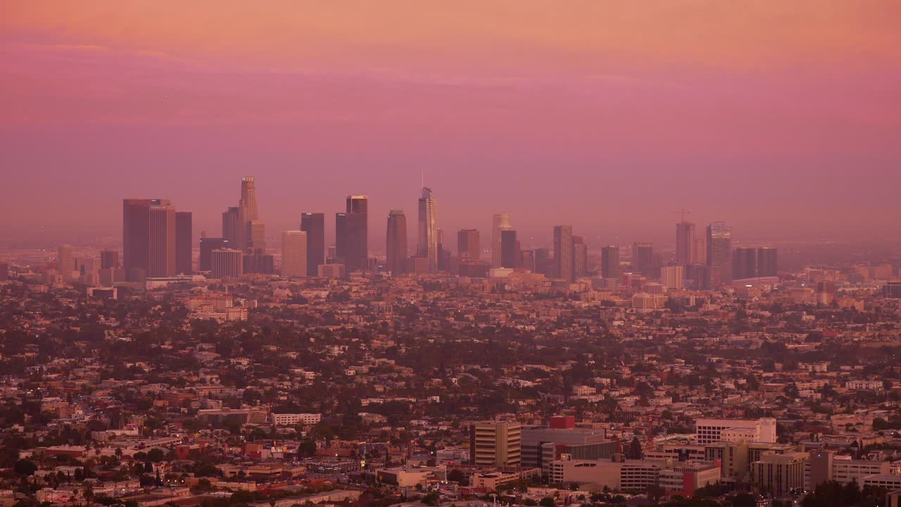 Timelapse of Los Angeles skyline at dusk at sunset with sky turning pink orange
