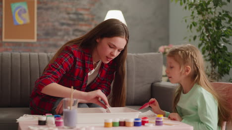 child looks at sister doing pattern with comb for ebru art