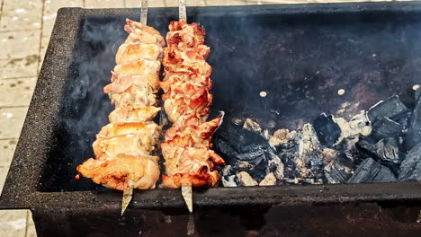 grilled chicken skewers cooking over charcoal, with smoke rising