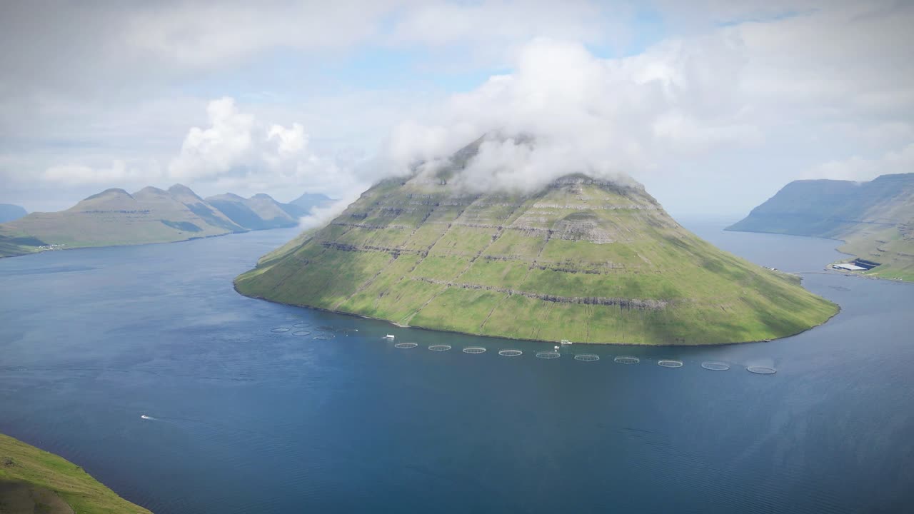 푸른 언덕과 안개가 가득한 산으로 둘러싸인 파로 제도 클라크스비크의 장엄한 피오르드는 먼 북유럽 풍경의 평화로운 아름다움과 평온한 해안의 매력을 반영합니다.