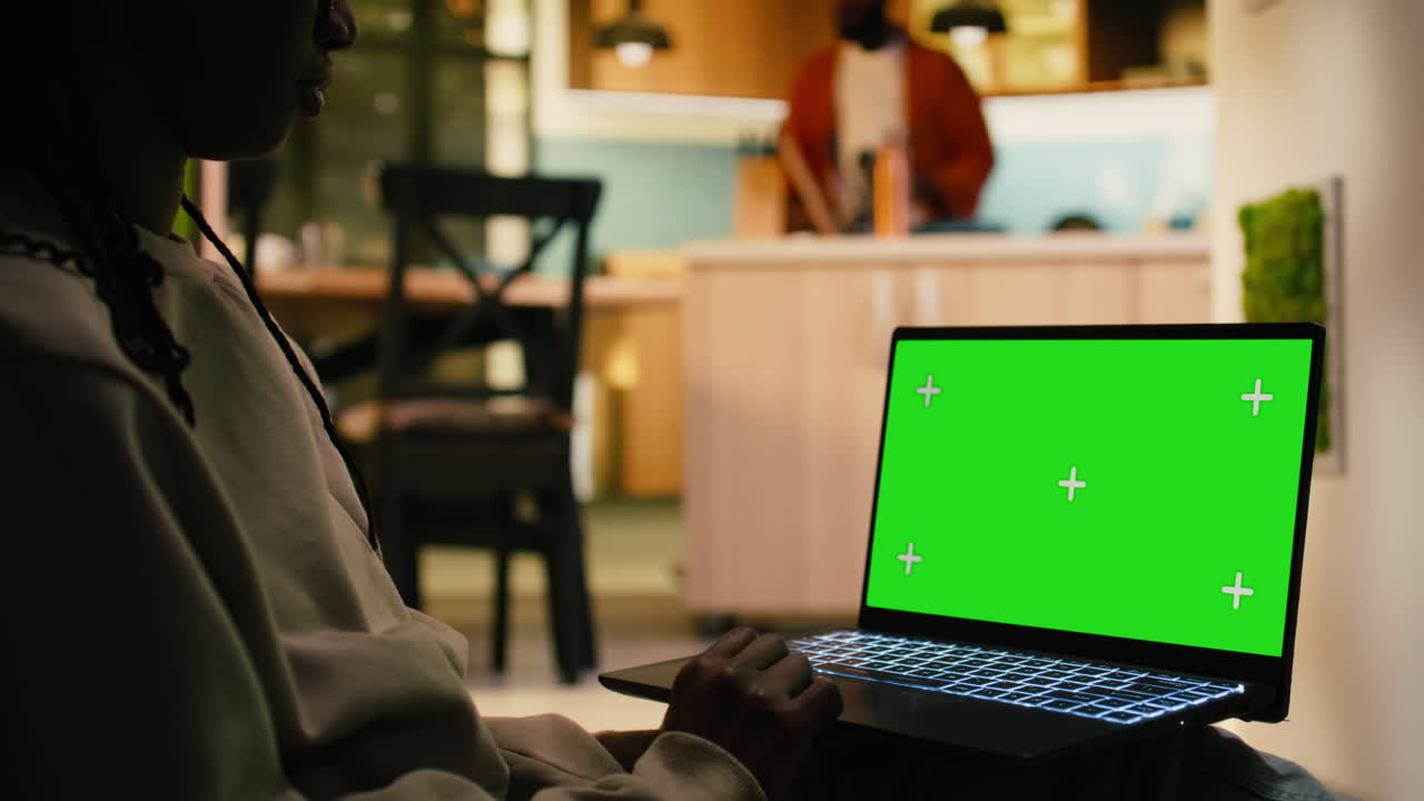 Chroma key sul laptop con una donna di colore che si rilassa nel corridoio di casa.