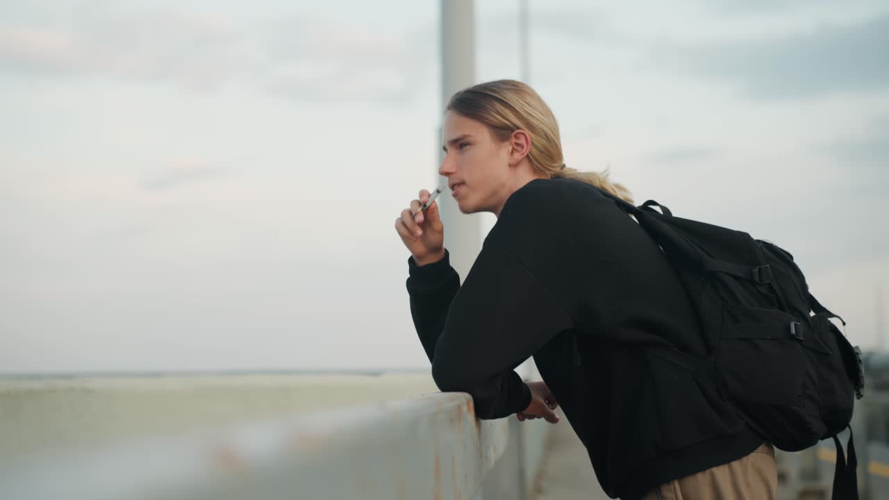 Giovane viaggiatore riflette. Giovane pensieroso in riva al mare. Adolescente contemplativo si rilassa vicino all'oceano al crepuscolo. Giovane avventuriero pensieroso si ferma al mare mentre il giorno sfuma nella notte.
