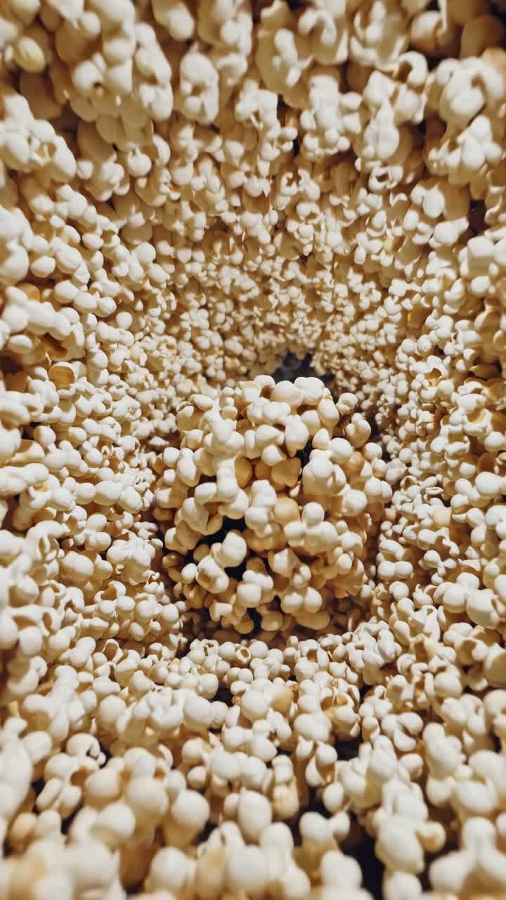 Close-up sequence of popcorn kernels creating a swirling tunnel effect in a dynamic motion