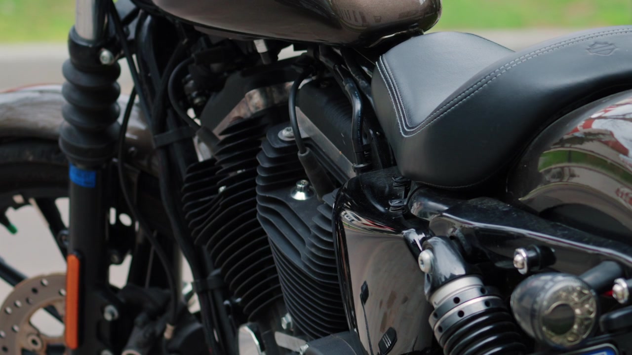 Primo piano di un motore di moto nero, sospensione posteriore e dettagli lucidi della carrozzeria