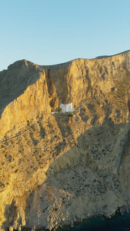 iconic greek orthodox monastery of panagia chozoviotissa glowing in early morning light, amorgos island. vertical