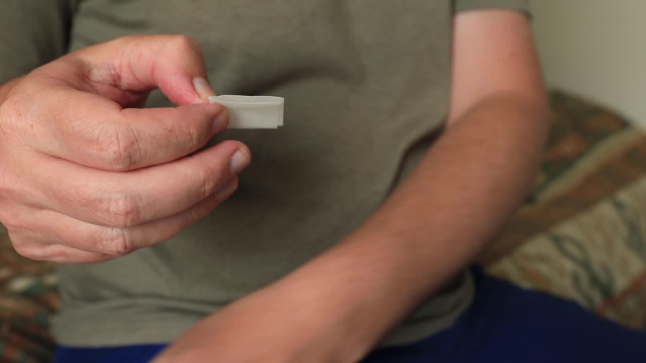 Opening up of and application of cleaning the abdomen with a wet hygiene disinfectant wipe in preparation to self apply medicine at home through a medical needle pen injecting the substance