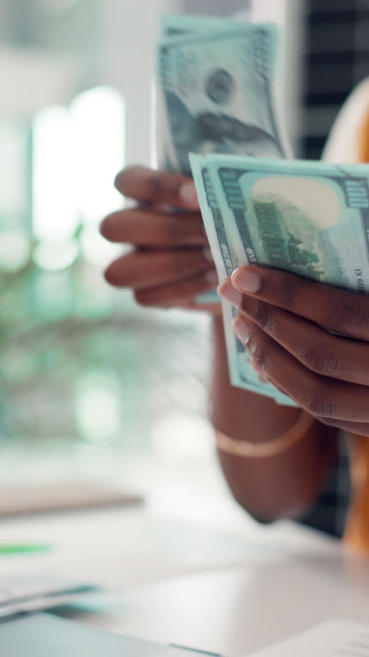 Mani che contano banconote da cento dollari statunitensi.