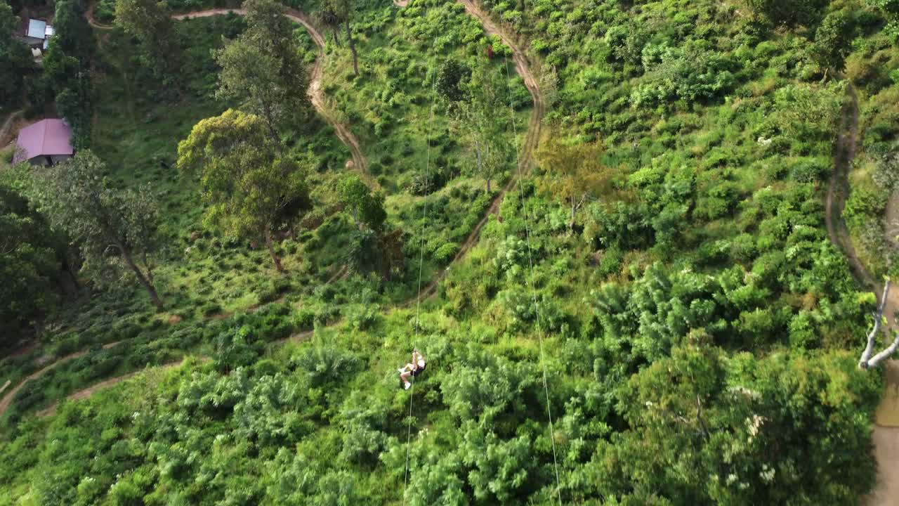 toma aérea de seguimiento de una persona irreconocible en tirolesa, sri lanka