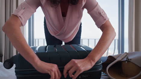 reife reisefrau, die zu hause koffer packt, für den ruhestand gelesen wird, urlaub vorbereitet, gepäck für den sommerurlaub vorbereitet