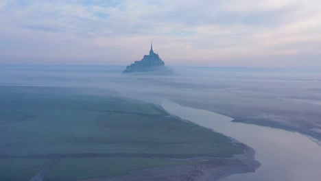 Moody-Increíble-Antena-De-Mont-Saint-Michel,-Francia-Saliendo-De-La-Niebla-Y-La-Niebla-Temprano-En-La-Mañana-3