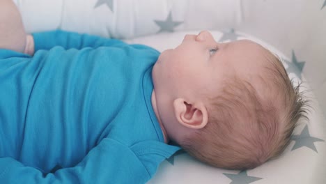 lovely-little-baby-in-bodysuit-rests-on-soft-sleeping-cocoon