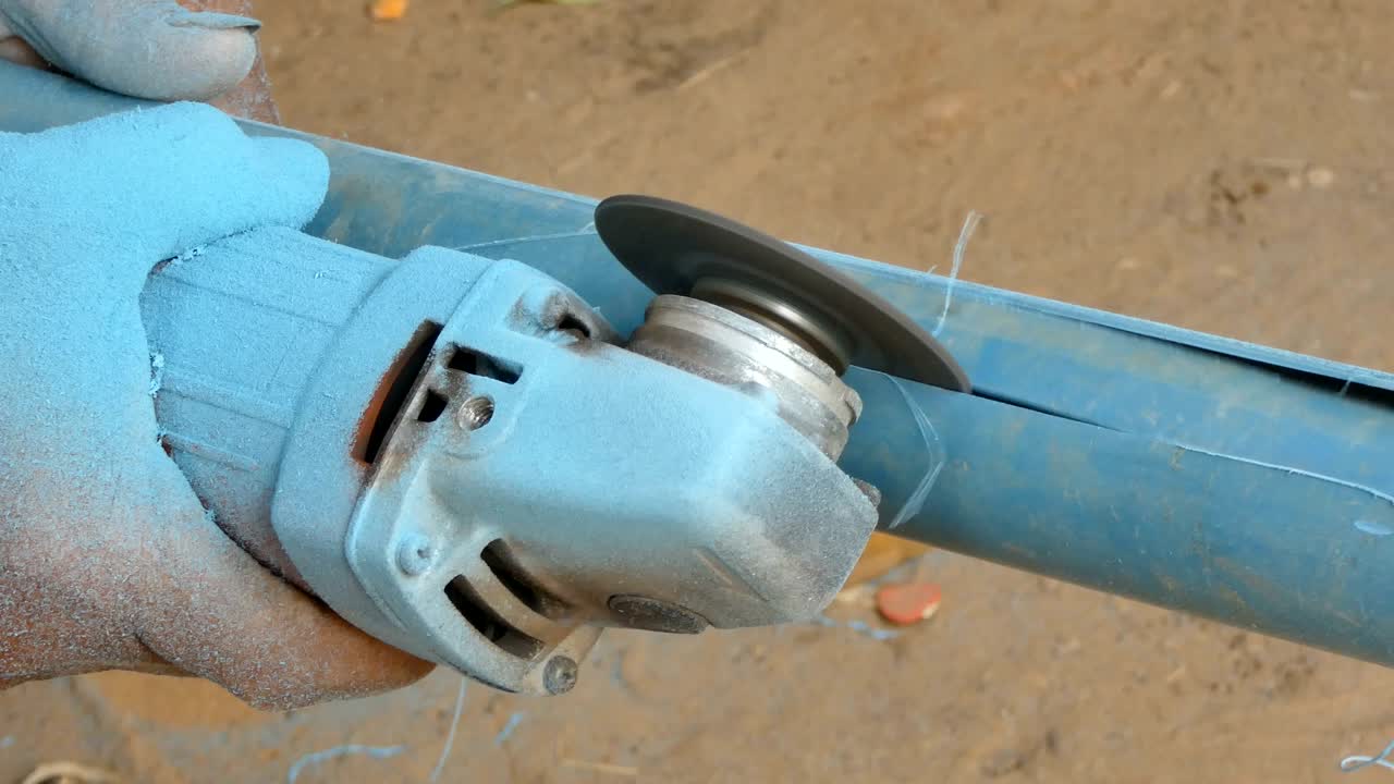 fotos cercanas de las manos de un mecánico que usa un molinillo eléctrico para deslizar una tubería de pvc cortada con sonido ambiental