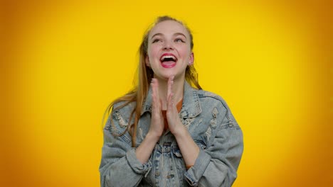 teen girl in denim jacket shouting, raising fists in gesture i did it, celebrating success, winning