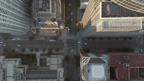 Street-crossing-in-a-big-City-in-between-Skyscrapers-and-View-of-Rooftops,-Los-Angeles,-Aerial-Birds-Eye-View-overhead-top-down-wide-shot