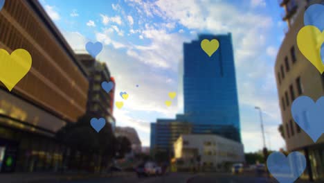 animación de corazones amarillos y azules flotando sobre el paisaje urbano
