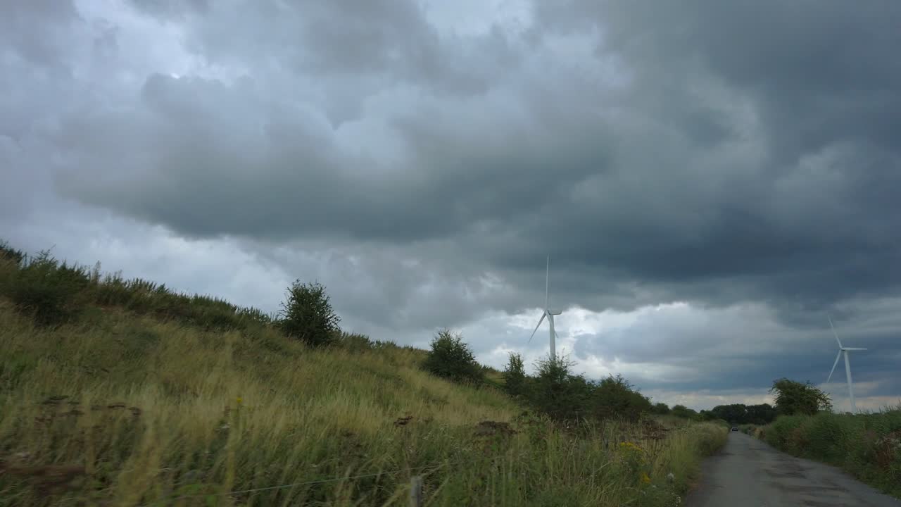 Tracking shot of turning wind turbine on cloudy day 2