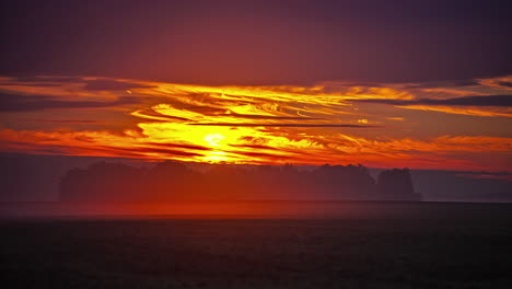 Golden-sunrise-as-the-wind-blows-in-over-a-farmland-field---long-duration-time-lapse