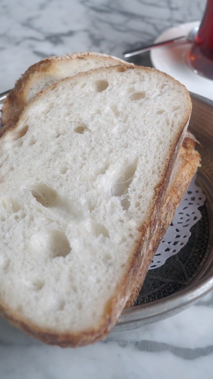 Slices of Fresh Sourdough Bread with Tea on a Marble Table