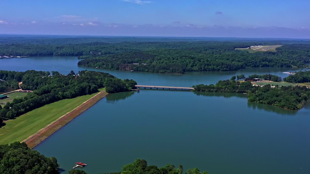 Ripresa aerea di un lago e di aree boschive attraversati da un ponte a Clemson, SC.