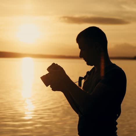 silhouette of photographer taking photos in the river at sunset time.