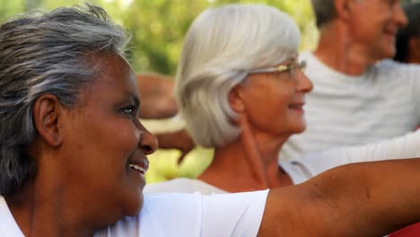 senior friends doing stretching exercise in garden 4k