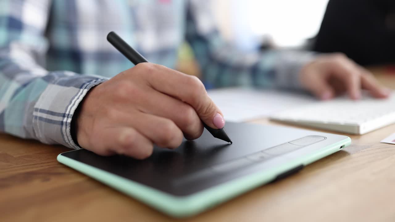 Closeup of graphics tablet and a woman hand