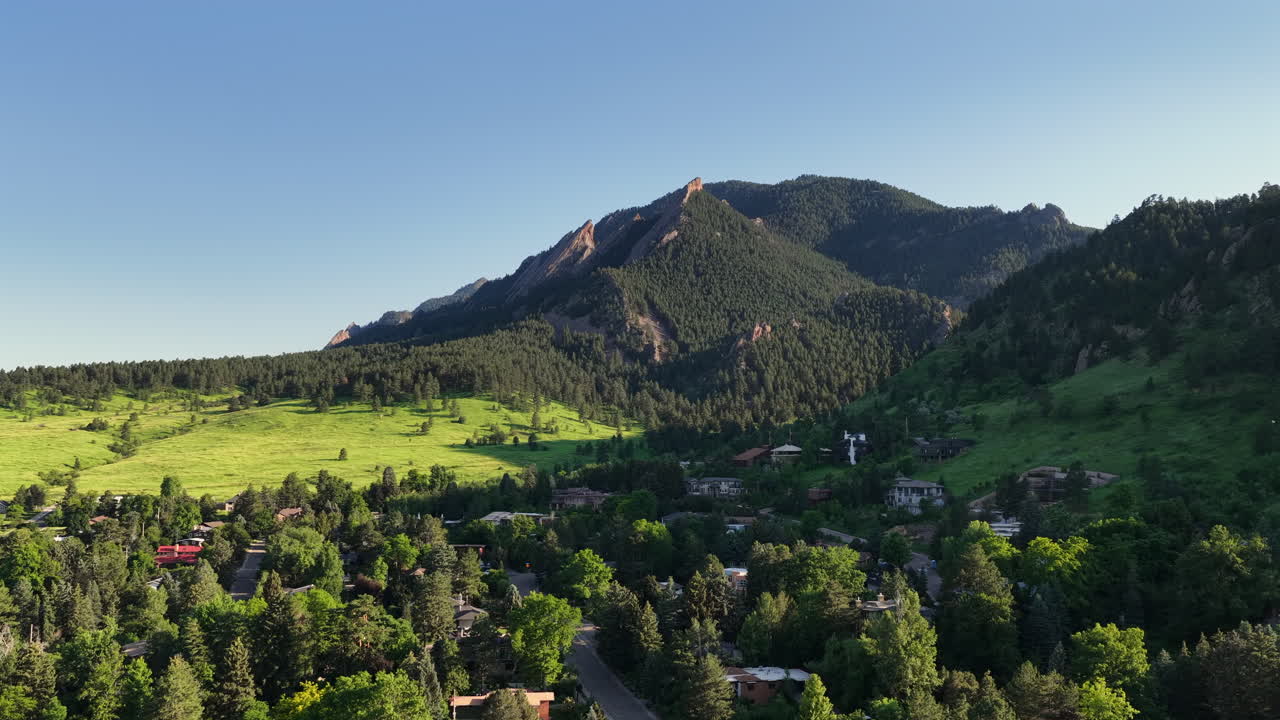 Drone footage of a summer sunset over the mountains near Boulder, Colorado. Aerial view of scenic wilderness, ridges, and forested landscapes.