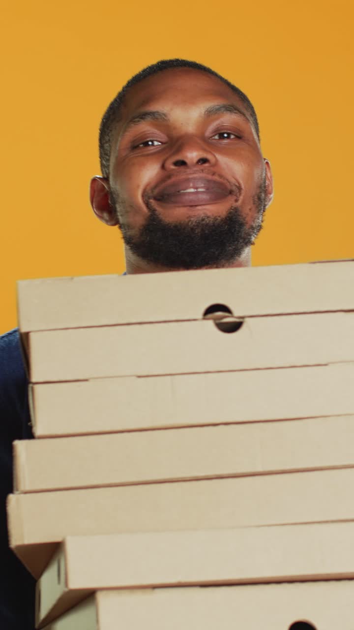 Smiling African American Man Holding Stack of Pizza Boxes