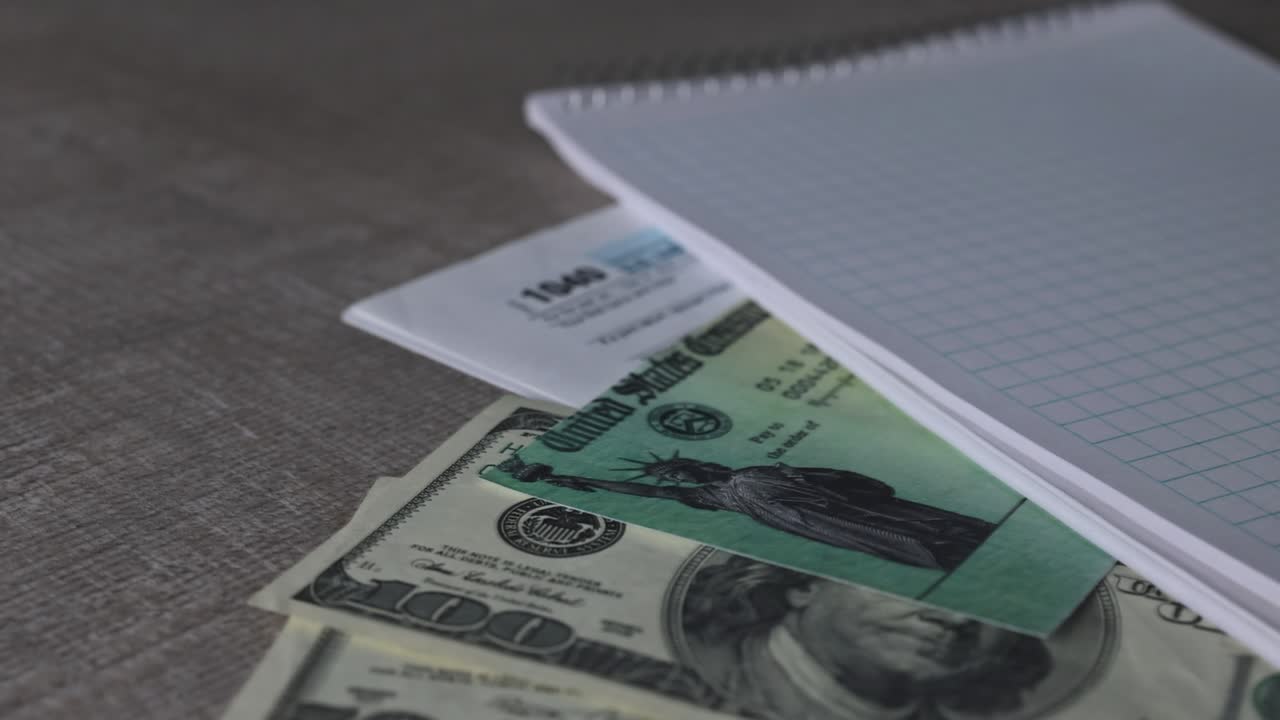 comprobación de retroceso de impuestos con moneda estadounidense y bloc de notas en espiral