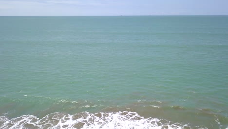 Vista-Aérea-De-Drones-De-La-Playa,-Turistas,-Mar-Y-Olas-Salpicando-En-La-Costa-En-Un-Día-Soleado-En-El-Pueblo-Playas-General-Villamil,-Ecuador