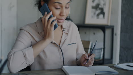 businesswoman on phone and taking notes
