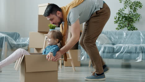 father and daughter playing in cardboard boxes during a move