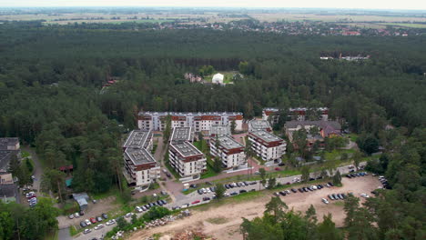 Vista-Aérea-De-Edificios-De-Apartamentos-Rodeados-De-árboles-Verdes-En-El-Bosque-De-Stegna,-Polonia