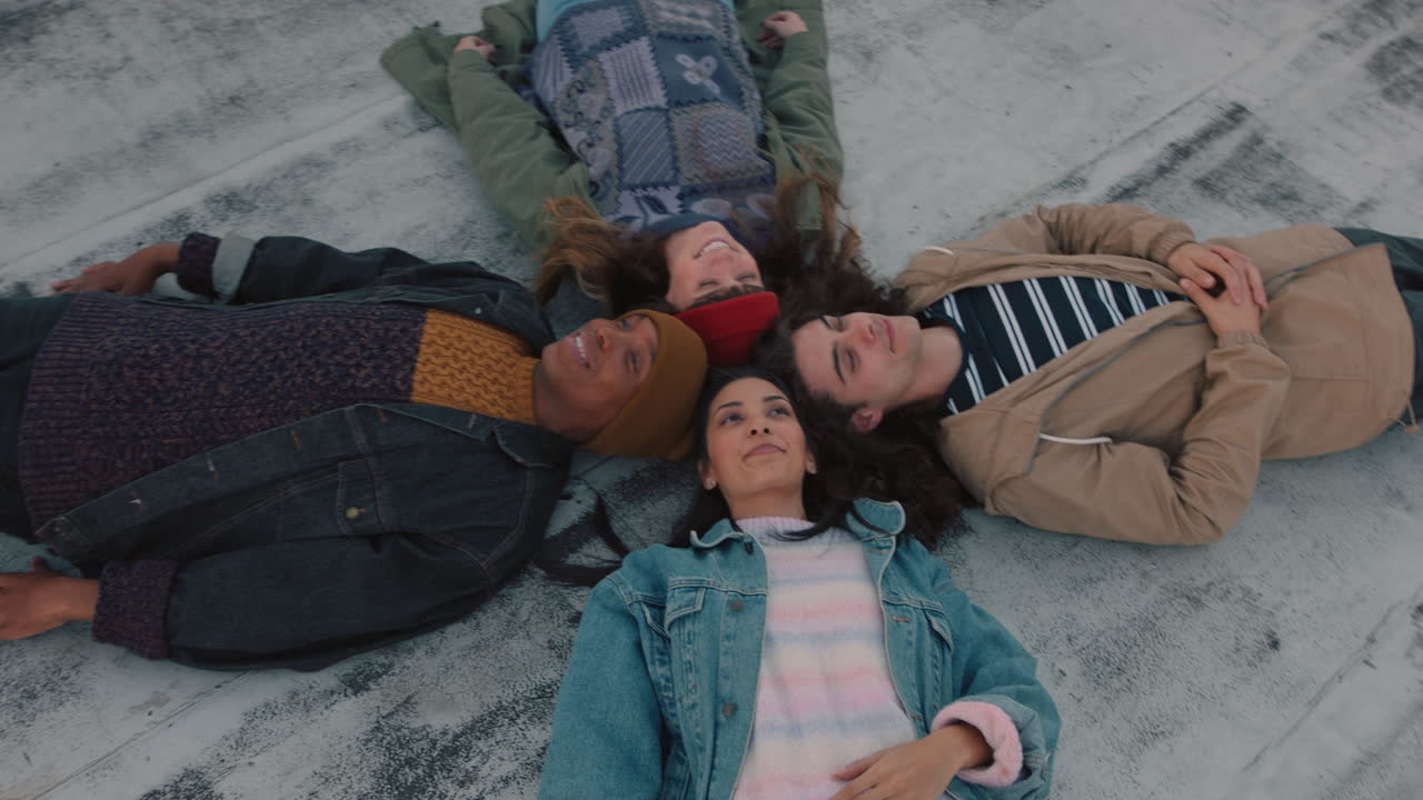 amigos felices pasando el rato acostados en la azotea mirando el cielo disfrutando de un fin de semana relajante juntos