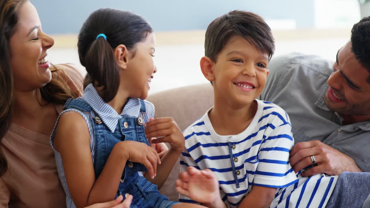 소파에 앉아서 거실에서 즐겁게 지내는 행복한 가족