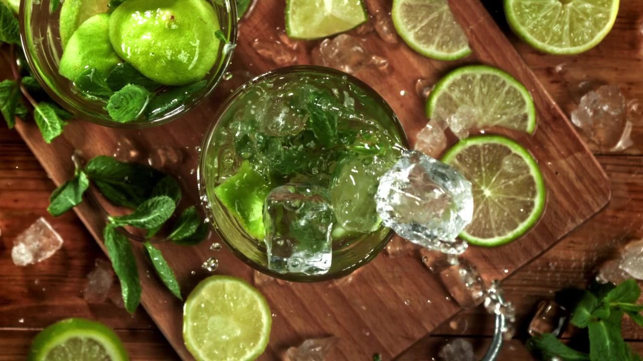 Cubetti di ghiaccio al rallentatore che si tuffano in un rinfrescante cocktail Mojito