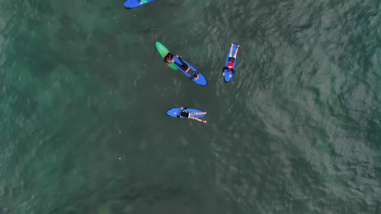 패들링과 서핑을 하는 서퍼의 공중 비디오를 닫습니다.